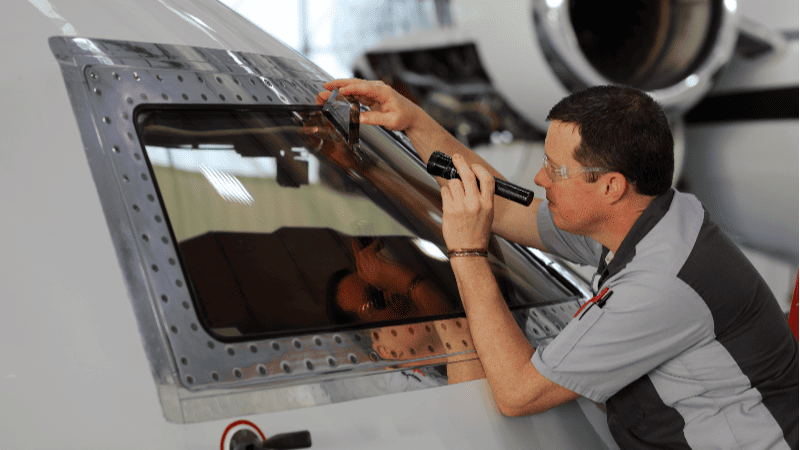 Technician inspecting an aerospace part with a flashlight